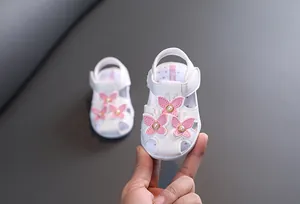 Vue détaillée de sandales blanches pour bébé fille avec papillon rose et perles