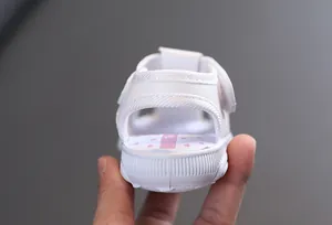 Détail macro d'une sandale blanche pour bébé fille avec bride de talon rembourrée