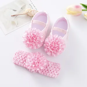 Détail des chaussures de princesse rose pour bébé avec volant et bandeau assorti