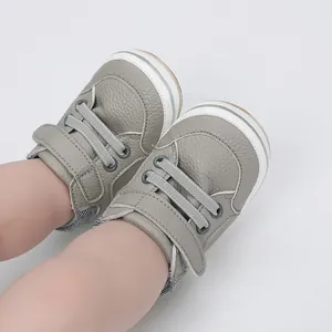 Detailed macro view of grey textured leather baby walking shoes with velcro strap