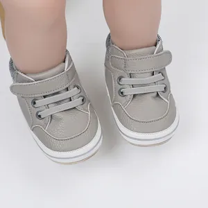 Detail view of gray faux leather baby boy walker shoes with velcro straps and white soles