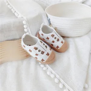 Detailansicht weißer Kleinkind-Segeltuchschuhe mit Bärenmuster und Shell-Toe-Design