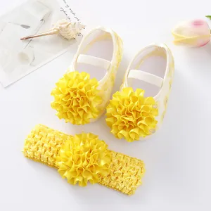 Gros plan détaillé des chaussures de bébé jaunes à fleurs et du bandeau assorti