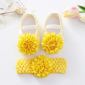 Gros plan sur les chaussures de princesse bébé jaunes avec fleurs en tissu et bandeau assorti