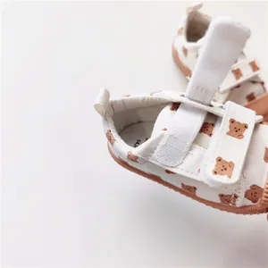 Detailansicht weißer Kinder-Stoffschuhe mit Bärenmuster und Klettverschluss für Babys
