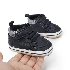 Detailansicht der dunkelblauen Babyschuhe mit Klettverschluss in der Hand gehalten