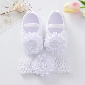 Vue détaillée de chaussures princesse pour bébé blanches avec bandeau à fleurs froufrous