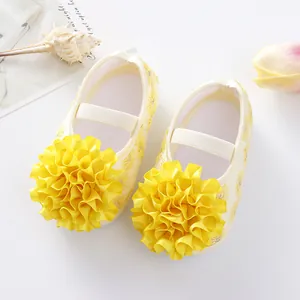 Detailed view of yellow baby princess shoes with large floral ribbon decorations