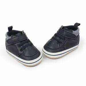 Detail view of navy blue baby pre-walker shoes with Velcro strap and striped collar.