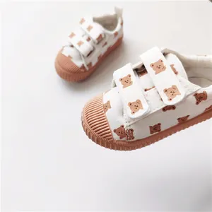 Detailansicht des braunen Bärenmusters auf weißen Klett-Canvas-Kinderschuhen