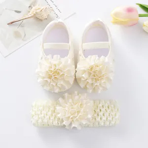 Gros plan détaillé de chaussures de princesse bébé crème et d'un bandeau floral assorti