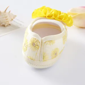 Close-up of baby girl princess shoe featuring delicate yellow daisy embroidery and ruffles