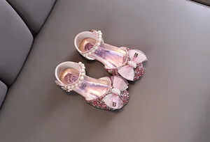 Dettaglio scarpe da principessa rosa per bambina con paillettes e perle