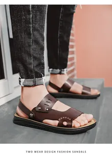 Macro view of men's two-wear brown PU leather sandals shown worn on concrete steps