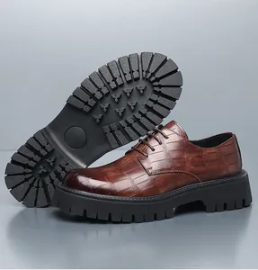 Vista detallada de zapatos de hombre en cuero marrón con relieve de cocodrilo y suela