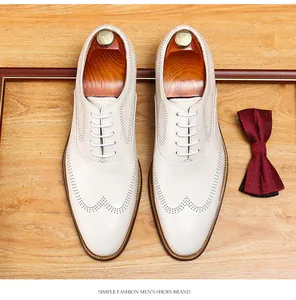 Top view detail of white men's wingtip brogue leather dress shoes with red bow tie