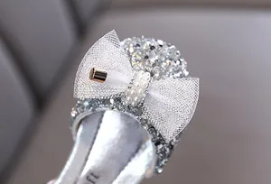 Vista dettagliata di scarpe da principessa glitter argento con fiocco e perle finte