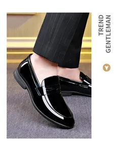 Primo piano di mocassini da uomo in pelle verniciata nera con pantaloni eleganti