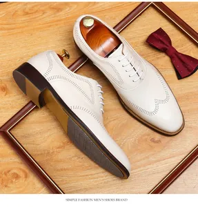 Elegant beige men's leather oxford shoes featuring classic brogue detailing and white laces