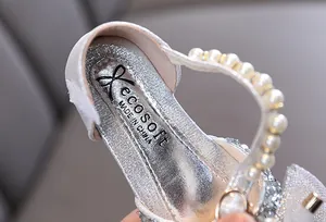 Primo piano di scarpe da principessa argento per bambina con perle e pizzo raffinato