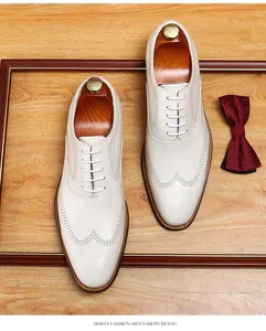 Detailed overhead view of elegant beige men's Brogue Oxford shoes on a wooden surface
