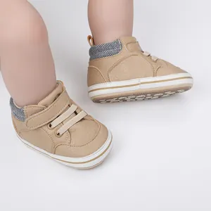 Detailansicht khakifarbener Babyschuhe aus Kunstleder mit Streifenkragen und Klettverschluss