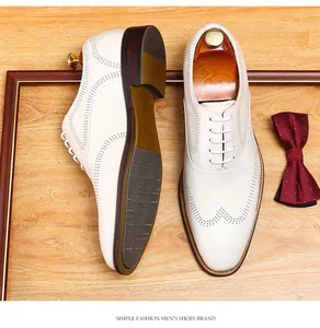 Close-up of white leather brogue shoes with decorative perforations and wooden shoe tree