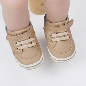 Detailed macro shot of khaki faux leather baby boy pre-walker shoes with velcro strap