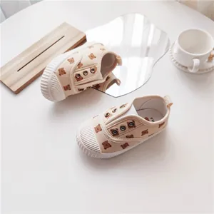 Detailansicht beige Kinder-Segeltuchschuhe mit Bärenmuster und Muschelzehen-Design.