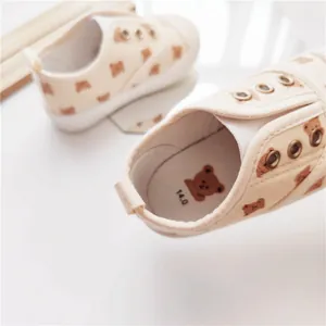 Detailansicht cremefarbener Kinder-Stoffschuhe mit Bärenmuster und weicher Sohle