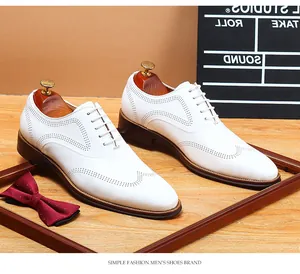 Detailed view of elegant white leather wingtip brogue dress shoes with laces for men.