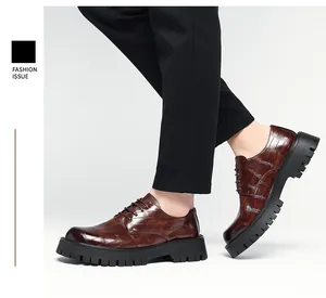 Vista lateral de zapatos de hombre en cuero marrón con patrón de cocodrilo y suela gruesa