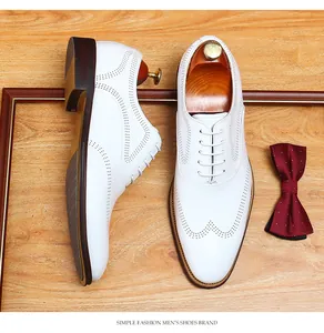 Macro view of white men's leather brogue shoes with elegant wingtip details