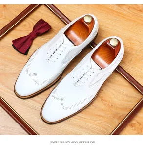 Detail view of men's white wingtip brogue shoes with elegant decorative props