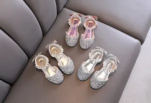 Dettaglio scarpe da principessa glitterate per bambine nei colori rosa, oro e argento.