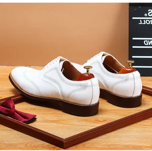 Detailed close-up showing the heel and perforation design on white leather brogue shoes