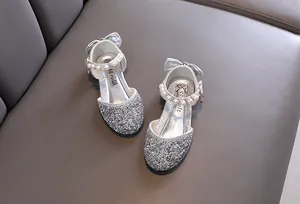 Dettaglio di sandali principessa argento con cinturino di perle e fiocco elegante