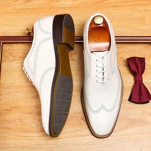 Elegant off-white men's wingtip brogue dress shoes with wooden shoe trees