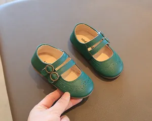Detail shot of green vintage-style Mary Jane shoes for girls with decorative cutouts