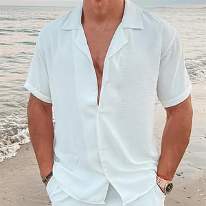 Detailweergave van een wit casual linnen overhemd met korte mouwen op het strand.