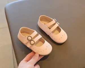 Detail view of pink girls' Mary Jane shoes with perforated patterns and gold buckles
