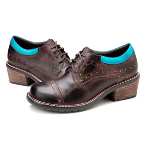 Close-up of brown leather Oxford shoes with colorful star cutouts and bright blue trim