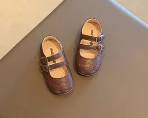 Classic brown girls Mary Jane shoes featuring brogue detailing and double metal buckles