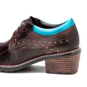 Macro side view of handmade brown leather chunky heel shoe with colorful star cutouts