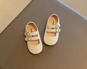 Elegant cream Mary Jane shoes for girls with double buckle straps and perforated details.