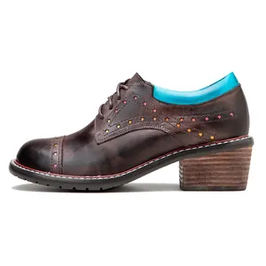 Close-up of brown leather Oxford shoe with colorful star-shaped cutouts and blue collar