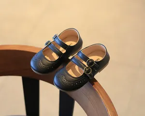 Close-up of black girls' Mary Jane shoes with brogue detailing and double straps.