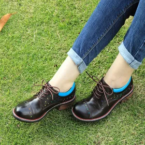 Detail view of retro brown leather lace-up shoes with colorful star cutouts