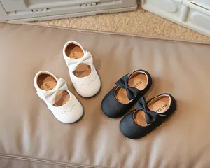 Hochwertige Detailaufnahme schwarz-weißer Kleinkind-Mädchen-Mary-Janes mit dekorativen Schleifen