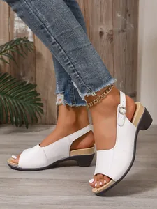 Gedetailleerd zicht op witte dames sandalen met sleehak en open teen aan de voeten.
